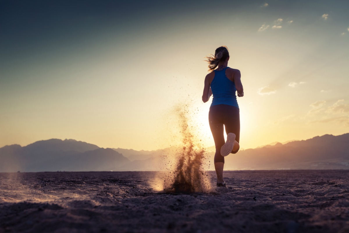 Lady running in the desert at sunset